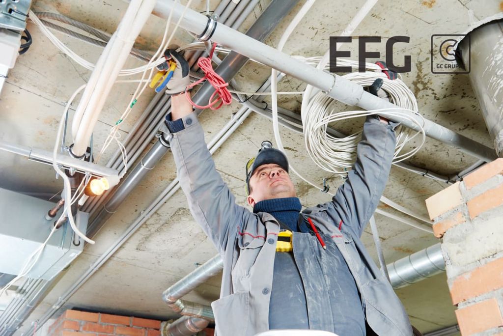 EFG-Handwerker verlegt Elektrokabel auf einer Baustelle